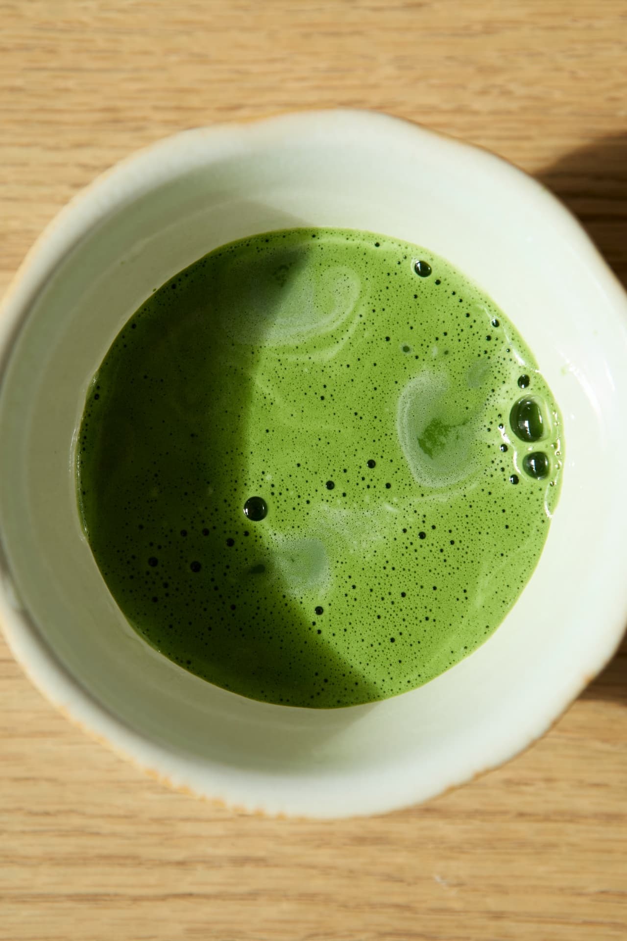 Overhead of frothed matcha in a white bowl
