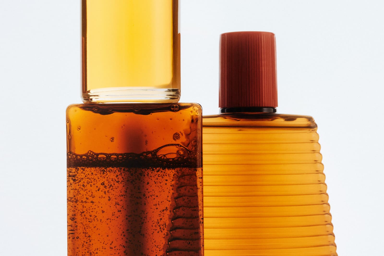 Two amber bottles, one open with liquid, one capped